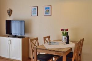 a dining room with a table with a television on a cabinet at Am Hof 1 unten in Staberdorf