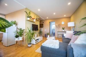 ein Wohnzimmer mit einem Sofa und Topfpflanzen in der Unterkunft Beautiful & spacious apartment in Valmiera in Valmiera