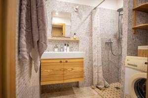 y baño con lavabo y ducha con cortina de ducha. en Beautiful & spacious apartment in Valmiera, en Valmiera