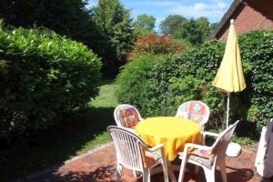 a yellow table and chairs with a yellow umbrella at Pastoratshof - Whg2 in Wrixum