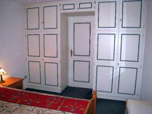 a room with two doors and a bed with a red rug at Pastoratshof - Whg2 in Wrixum