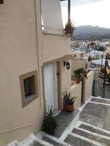 a building with a door and a balcony with plants at Kelly's studio SISAMOS in Karpathos