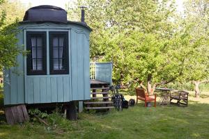 a tiny house in a yard with a table and chairs at Zirkuswagen in Kirch Mulsow