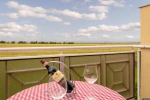 una botella de vino sentada en una mesa con dos copas en FerienDüne 4, en Kägsdorf