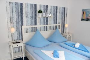 una camera da letto con letto e cuscini blu di LANDHAUS AM HAFEN im EG a Heiligenhafen