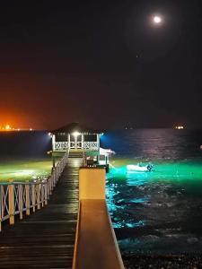 a dock with a boat on the water at night at Apartamento con vista a Islas Ballestas in Paracas