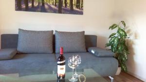 una botella de vino en una mesa junto a un sofá en Ferienwohnung Klein am Natursteig Sieg, en Bitzen
