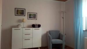 a room with a chair and a dresser with a camera at Ferienwohnung Klein am Natursteig Sieg in Bitzen