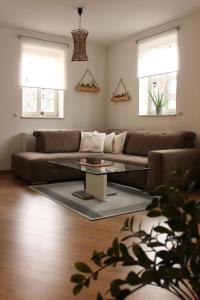 a living room with a couch and a glass table at Ferienwohnung "Zum Schloßkeller" in Wolkenstein