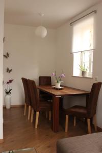 Ferienwohnung "Zum Schloßkeller" في فولكنشتاين: غرفة طعام مع طاولة وكراسي خشبية