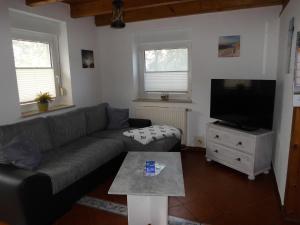 a living room with a couch and a flat screen tv at Möwennest in Neuharlingersiel