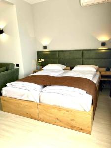 uma cama grande com uma estrutura de madeira num quarto em Апарт-отель Nine Rooms em Yerevan