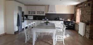 a kitchen with a white table and white chairs at Casa Souto Robledo in Calabreo
