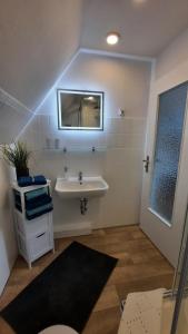 a bathroom with a sink and a mirror at De Lüdde Mangelstuv in Bredstedt