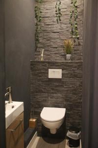 a bathroom with a white toilet and a brick wall at Studio Design Plage des Catalans in Marseille