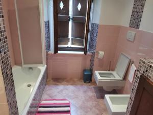 a pink bathroom with a sink and a toilet at b&b da Alberto in Arcevia