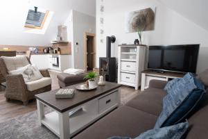 a living room with a couch and a tv at Ostsee - Appartement Nr 70 "Beachklause" im Strand Resort in Heiligenhafen