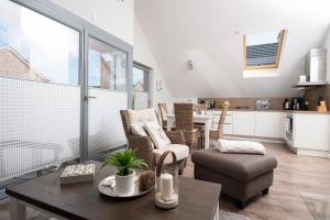 un soggiorno con tavolo e sedie e una cucina di Ostsee - Appartement Nr 70 "Beachklause" im Strand Resort a Heiligenhafen