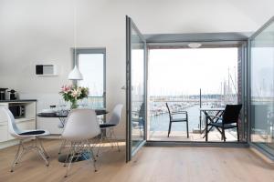 a kitchen and dining room with a view of the water at Ostsee - Appartement Nr 55 "Marina Loft" im Strand Resort in Heiligenhafen