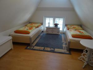 a attic room with two beds and a table at Kranich - a09374 in Zingst