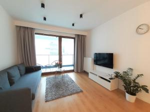sala de estar con sofá azul y TV en Vista Residence Premium en Varsovia