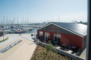 a red building at a marina with boats at Ostsee - Appartement Nr 75 "Beletage" im Strand Resort in Heiligenhafen