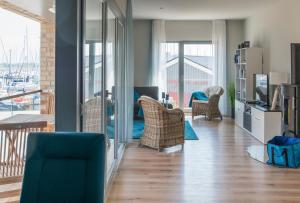ハイリゲンハーフェンにあるOstsee - Appartement Nr 75 "Beletage" im Strand Resortの椅子付きの部屋、バルコニー付きのリビングルームが備わります。