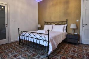 a bedroom with a black bed with white pillows at Xeuchia Accommodation in Xewkija