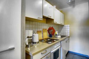a kitchen with white cabinets and a stove top oven at Seerengeti in Zingst