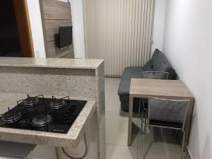 uma cozinha com fogão forno ao lado de um sofá em Flat Essenciale Style 1506 em Goiânia