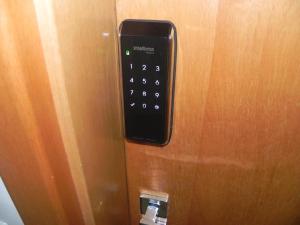 um controlo remoto no lado de uma porta de madeira em Flat Essenciale Style 1506 em Goiânia mais 1 fotografia