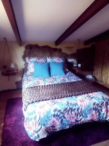 a bedroom with a large bed with blue pillows at La casa de los Bonales in Arroyomolinos de León