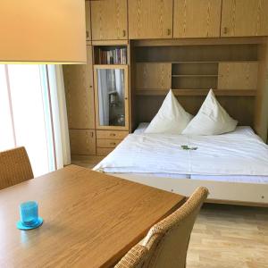 um quarto com uma cama e uma mesa de madeira em Haus am Kurpark - Strandmuschel em Grömitz