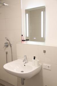 lavabo blanco en el baño con espejo en Casa Kronengarten Nr 4 en Hilden