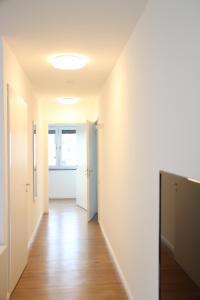 un pasillo vacío con paredes blancas y suelo de madera en Casa Kronengarten Nr 4, en Hilden