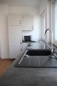 cocina con fregadero y microondas en Casa Kronengarten Nr 4, en Hilden