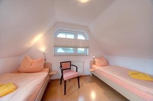 ツィングストにあるStrandglück FH 2のベッド2台、椅子、窓が備わる客室です。