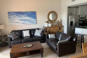 a living room with black leather couches and a kitchen at Luxury and Spacious Waterside Getaway in Clearwater Beach