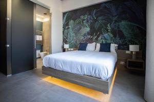 a bedroom with a large bed with a painting on the wall at L'élégant BOUTIQUE ROOMS NAPLES in Naples