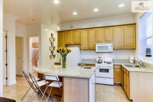 a kitchen with wooden cabinets and a vase of flowers at 200-surf Stars Penthouse in San Diego
