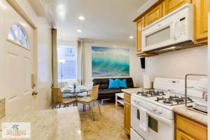 a kitchen with a stove and a living room at 199-surf Stars Combo in San Diego