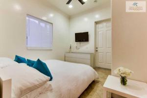 a bedroom with a white bed and a tv at 199-surf Stars Combo in San Diego