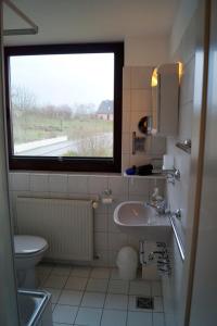 GrödersbyにあるFeWo Leuchtfeuerのバスルーム(洗面台、トイレ付)、窓が備わります。
