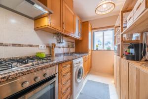 a kitchen with a stove and a washing machine at Cozy and Stylish Beach Flat in Armação de Pêra