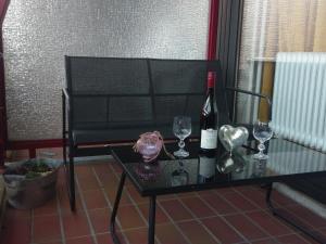 ハーネンクレー・ボックスヴィーゼにあるBerg Harmonie Haus 4 Jahreszeitenのワイン1本とグラスをテーブルに用意しています。