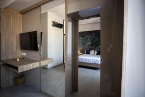 a room with a bedroom with a bed and a television at L'élégant BOUTIQUE ROOMS NAPLES in Naples