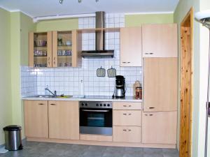 a kitchen with wooden cabinets and a stove at Hütigendachs, FW 7 in Zingst