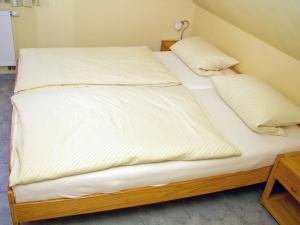 a bedroom with two beds with white sheets and pillows at Hütigendachs, FW 7 in Zingst