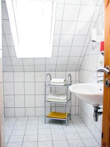 a white bathroom with a sink and a mirror at Hütigendachs, FW 7 in Zingst