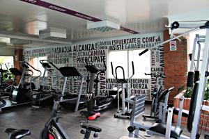 um ginásio com máquinas de rodagem e uma parede com crições em Hotel Ciudad Bonita em Bucaramanga